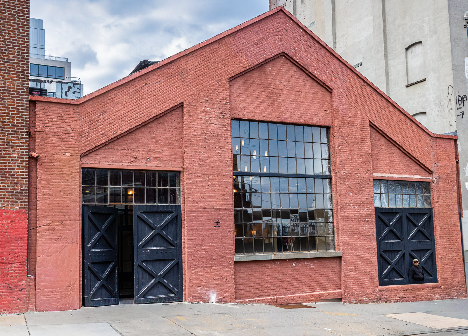 26 Bridge exterior showcasing historic brick architecture, oversized windows, and a clean industrial entrance.