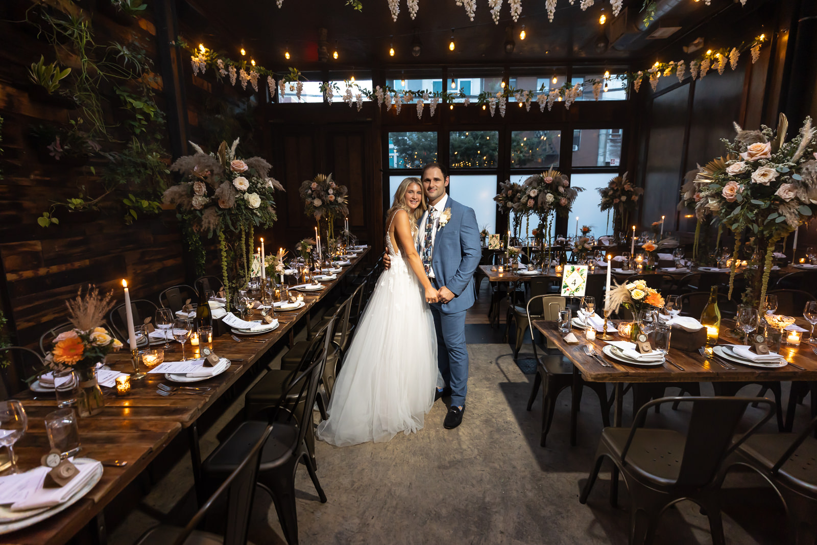 Bride and groom portrait between reception tables at Brooklyn Winery.