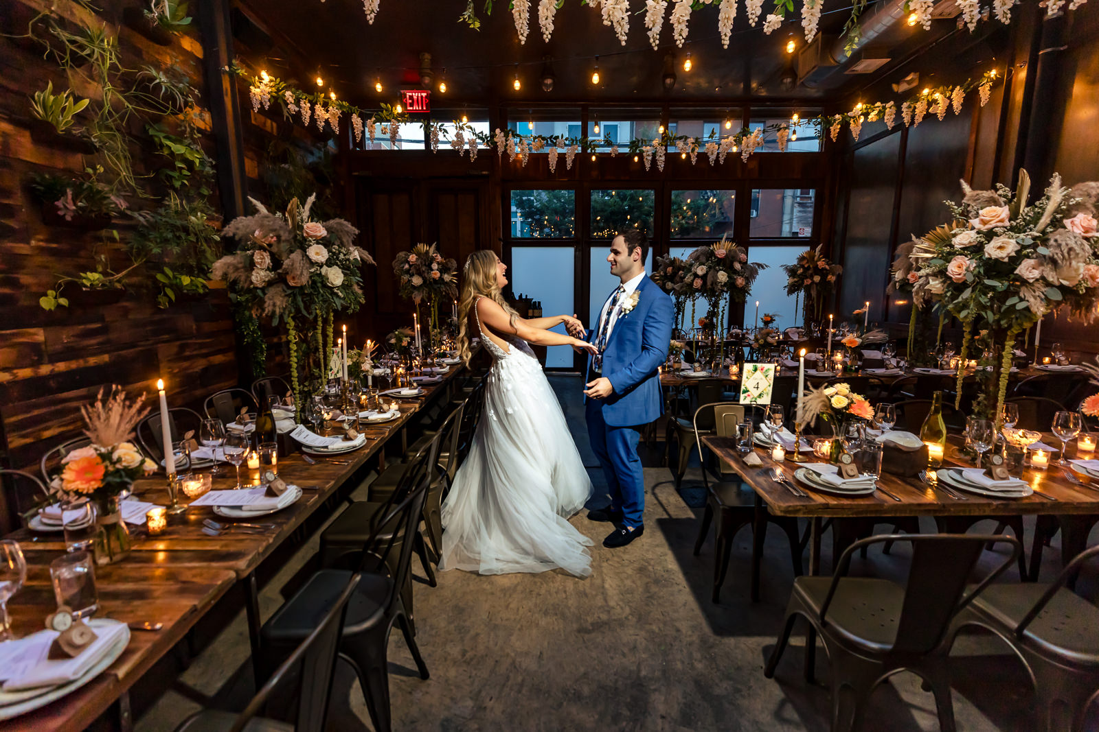 Bride and groom portrait among reception tables at Brooklyn Winery.