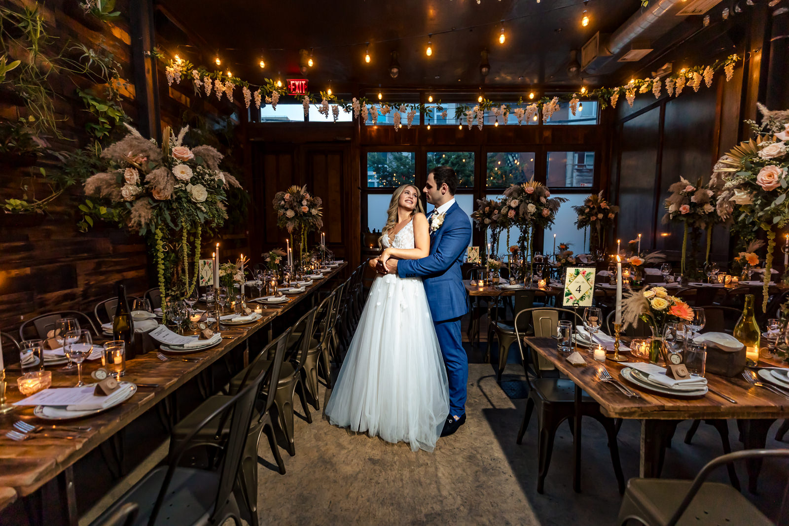 Paola and Alex standing together inside Brooklyn Winery reception space.