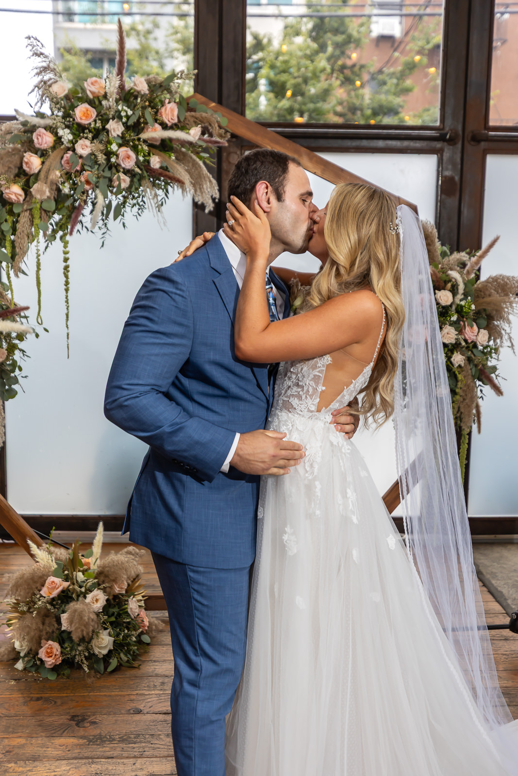 Newlyweds sharing a kiss during their Brooklyn Winery wedding ceremony.